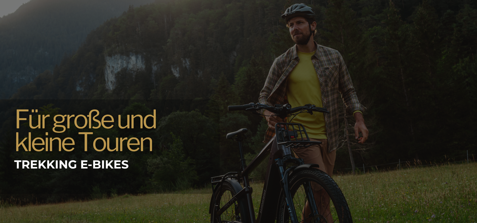 Fahrradfahrer schiebt sein Trekking E-BIKE &uuml;ber eine Wiese